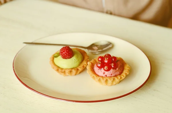 Deliciosas tartaletas con bayas frescas sobre la mesa en la cafetería —  Fotos de Stock