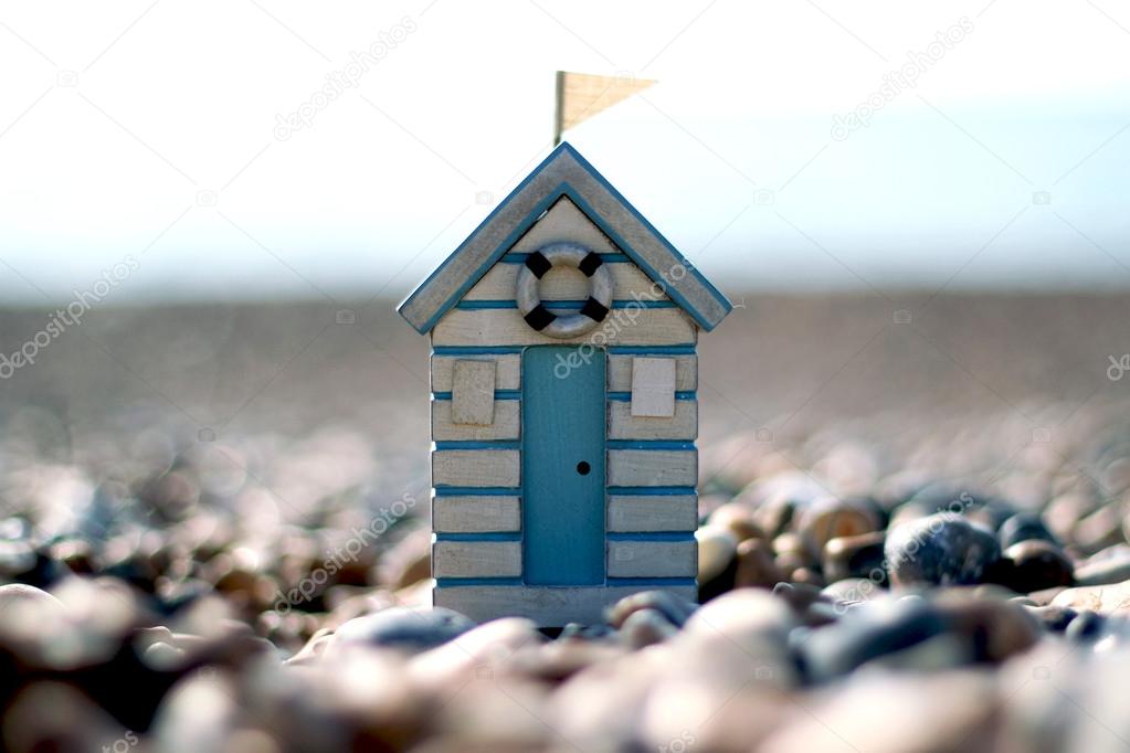 A toy beach hut on a pebble beach
