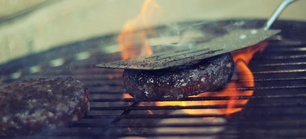 Beef burger being grilled on a barbecue — Stock Photo, Image