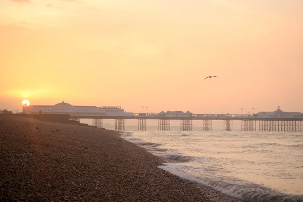 Sunrise over a pier on a beach in Brighton — Stock Photo, Image