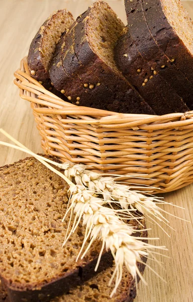 Basket with bread and wheat on the table — Stock Photo, Image