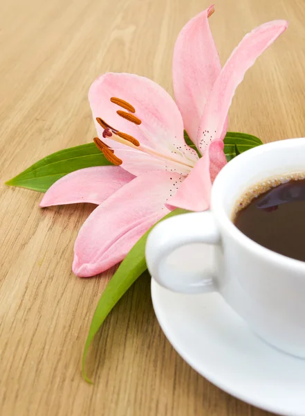 Cup of coffee and pink lily — Stock Photo, Image