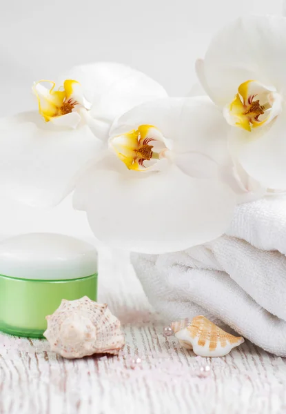 Hydraterende crème met orchideeën en handdoek — Stockfoto