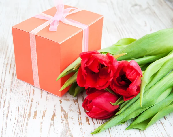 Boeket van tulpen, doos van de gift op een tafel — Stockfoto