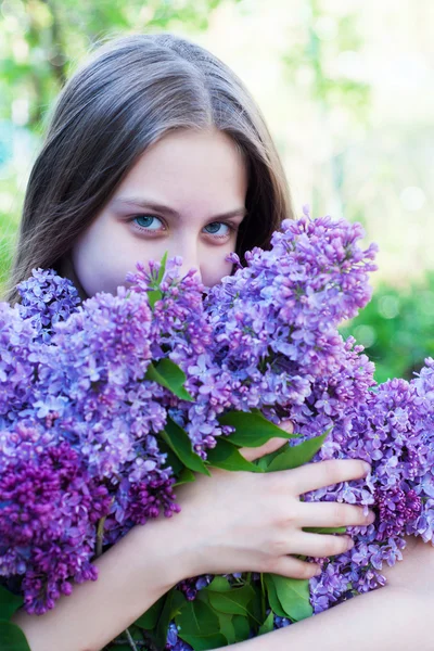 Vacker flicka med lila blommor — Stockfoto