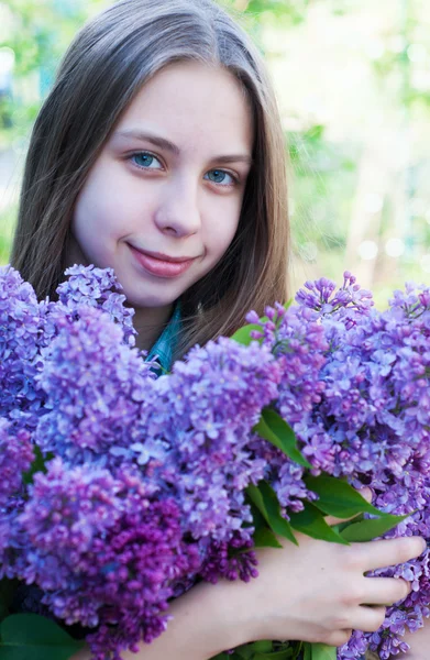 Schönes Mädchen mit lila Blüten — Stockfoto