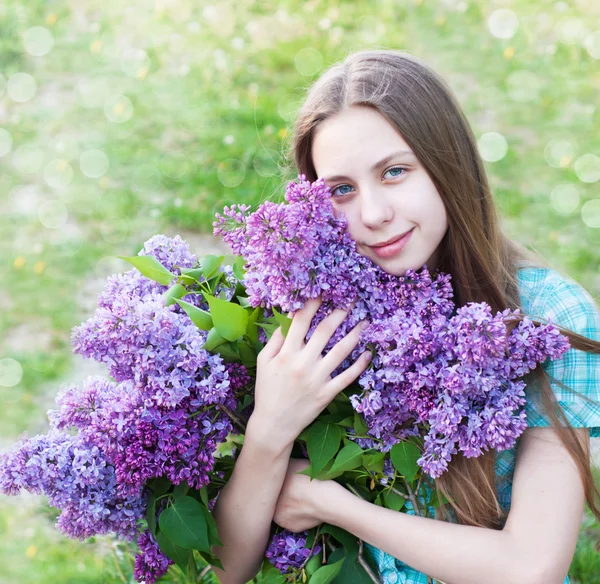 Vacker flicka med lila blommor — Stockfoto