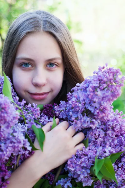Schönes Mädchen mit lila Blüten — Stockfoto