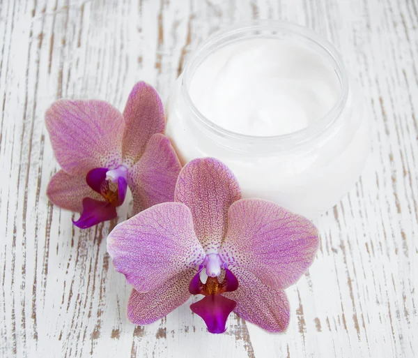 Crema facial con flores de orquídeas —  Fotos de Stock