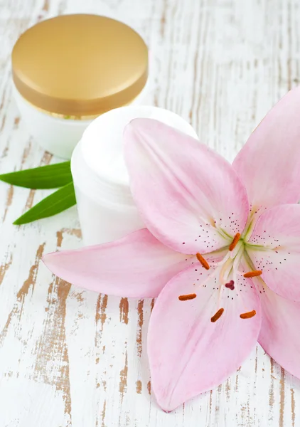 Gezichtscrème met lily bloemen — Stockfoto
