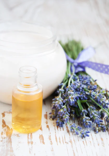 Container with cream, massage oil and lavender — Stock Photo, Image
