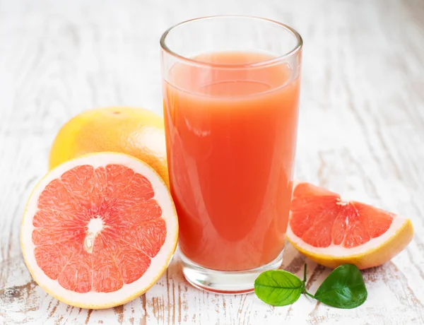 Грейпфрутовый сок и спелые грейпфруты — стоковое фото