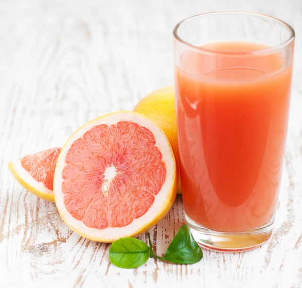 Грейпфрутовый сок и спелые грейпфруты — стоковое фото