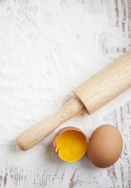 Flour and eggs on a wooden board — Stock Photo, Image