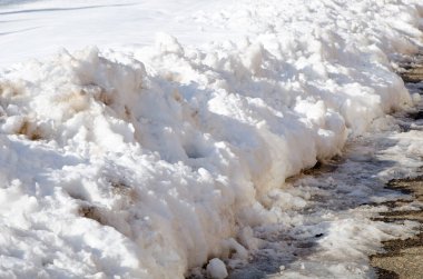 Kaldırımda kar yığını var. Kışın karlar kalkar.