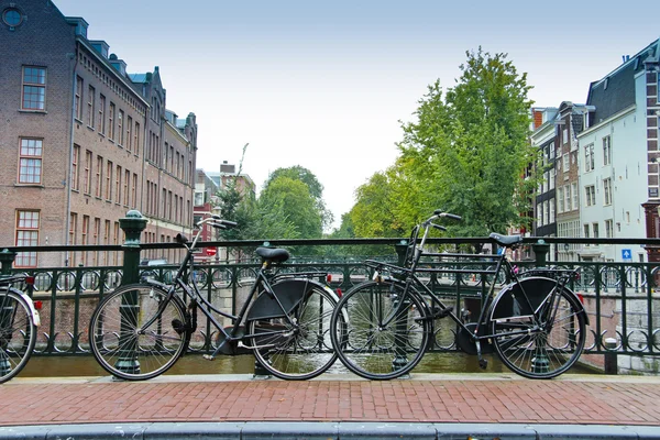 Par cyklar över kanalen i amsterdam — Stockfoto