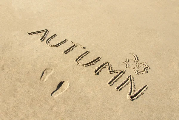Woord herfst handgeschreven en blad in zand getrokken — Stockfoto