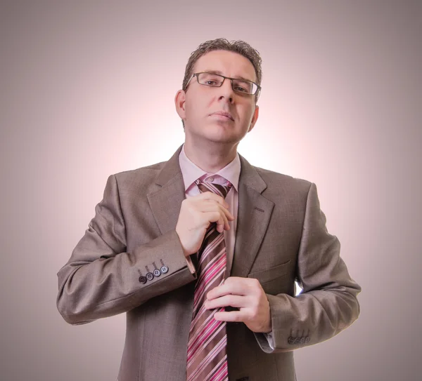 Thoughtful businessman putting his tie on white background — Stock Photo, Image