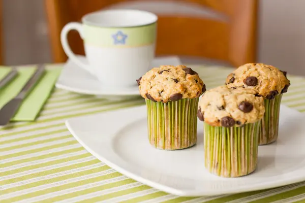 Muffins de viruta de chocolate en plato blanco y mantel rayado verde —  Fotos de Stock