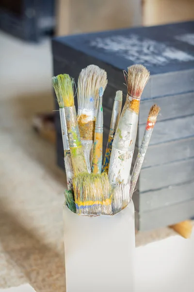 Set of paint brushes in front of canvas — Stock Photo, Image