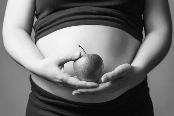 Pregnant woman holding a red apple in her hands — Stock Photo, Image