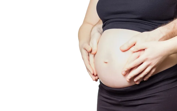 Pregnant woman touching her belly with hands and her husband too — Stock Photo, Image