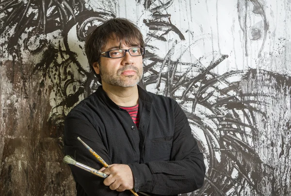 Painter artist posing in front of paint — Stock Photo, Image