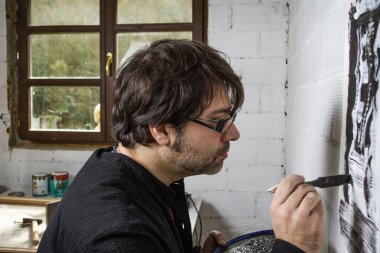 Petrol tuval üzerinde çalışan ressam sanatçı