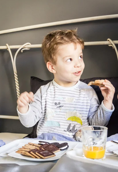 Niño desayunando en la cama — Foto de Stock