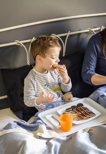 Mother and son having breakfast in bed — Stock Photo, Image