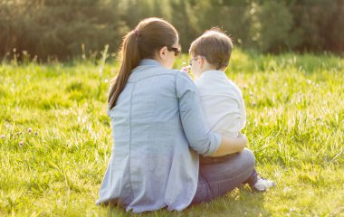 sevimli oğlu oturan annesi için bir buket çiçek veren bir