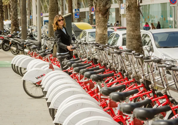 Belle fille prenant un vélo de rangée dans la rue, à Barcelone , — Photo