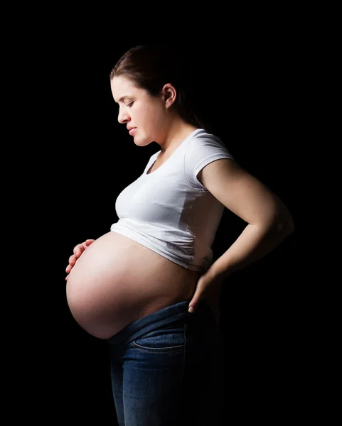 Gyönyörű várandós, terhes, keresi a hasát, elszigetelt — Stock Fotó