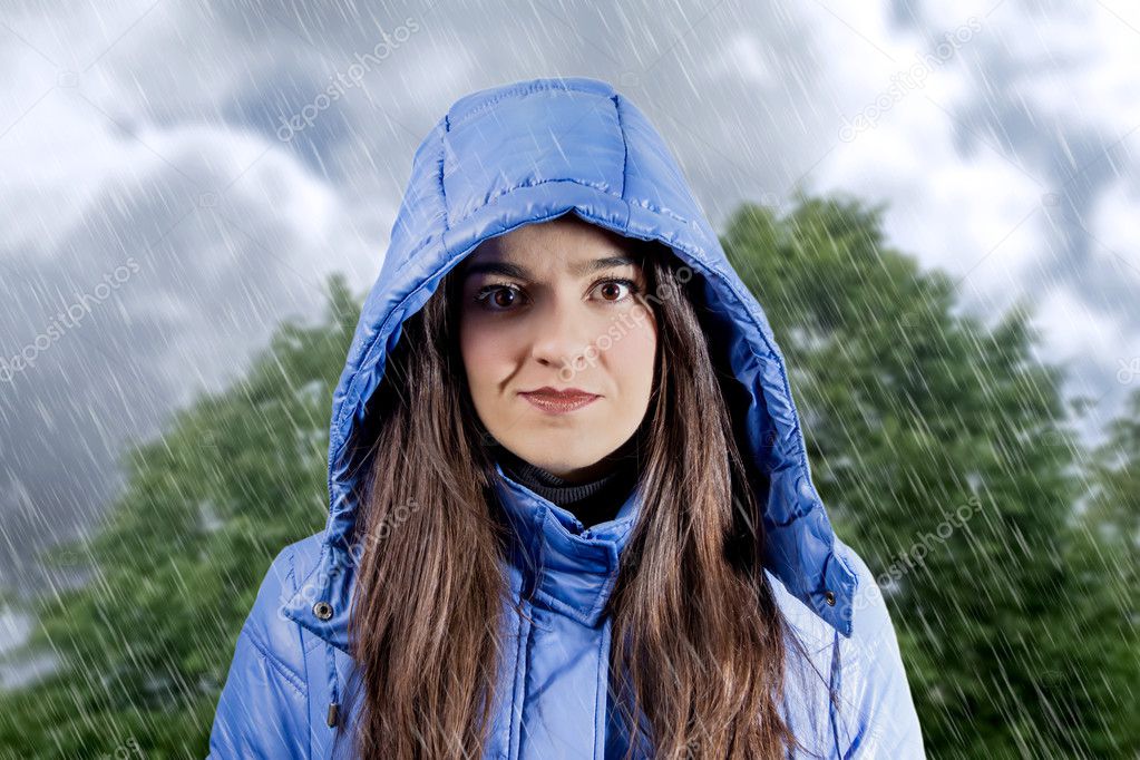 Portrait of beautiful young girl wearing raincoat with hood