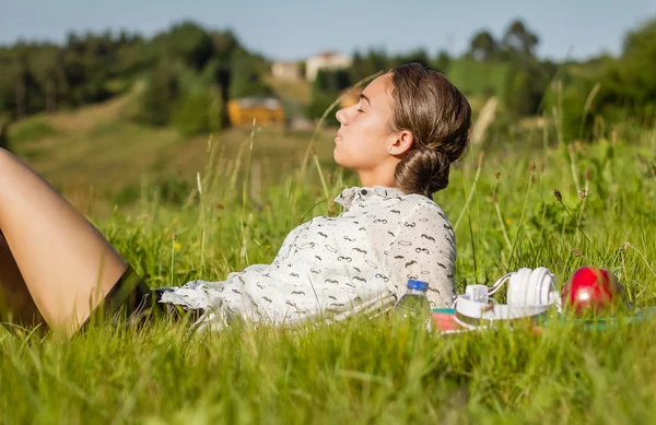 Vacker ung student liggande på park i en solig dag — Stockfoto