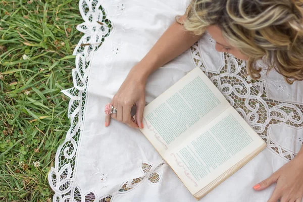 Çimenlerin üzerinde kitap ile güzel kız — Stok fotoğraf