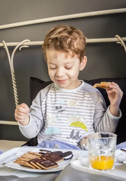 Child having breakfast in bed — Stock Photo, Image