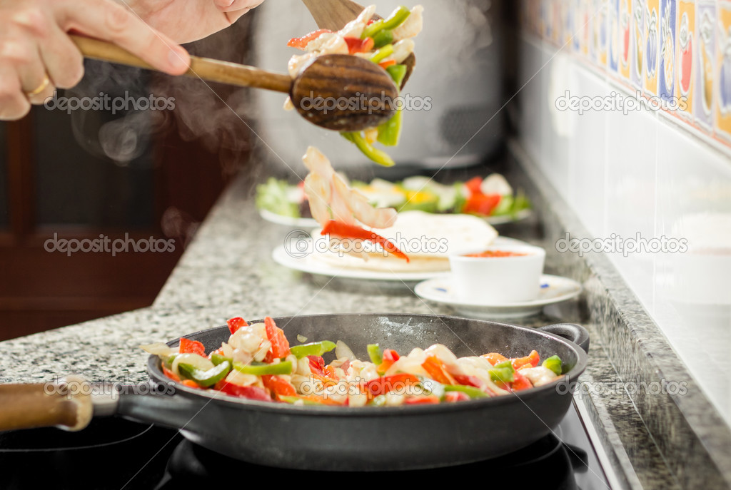 Closeup of man cooking vegetables and chicken in a pan