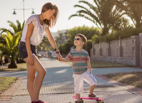 Chica joven y lindo niño con un skateboards al aire libre —  Fotos de Stock