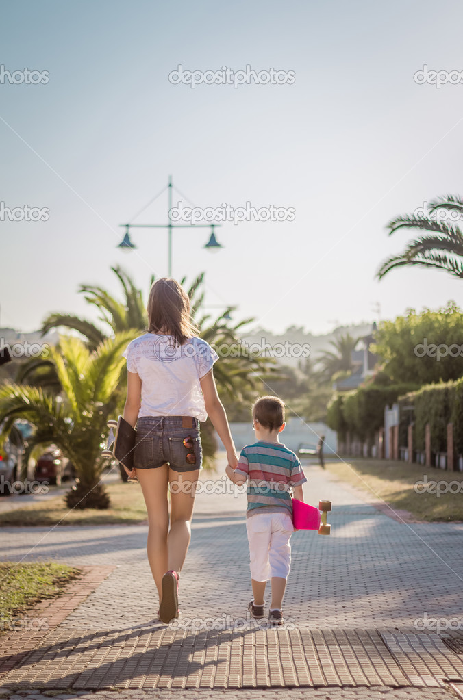 Young girl and cute kid with a skateboards outdoor
