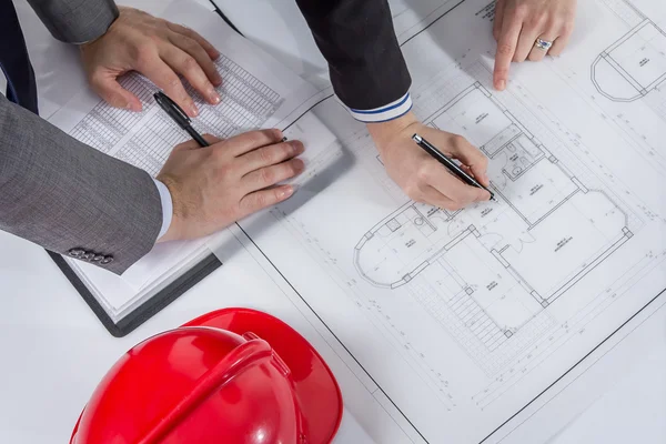 Above view of architects hands revising a house project — Stock Photo, Image