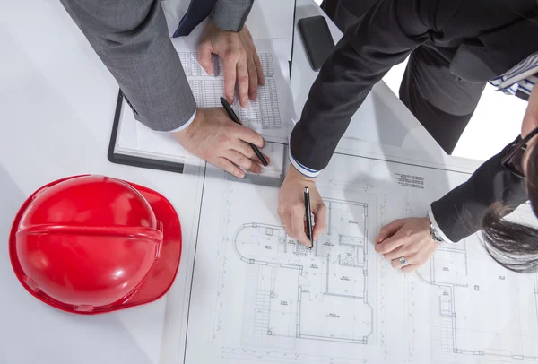 Above view of architects hands revising a house project — Stock Photo, Image