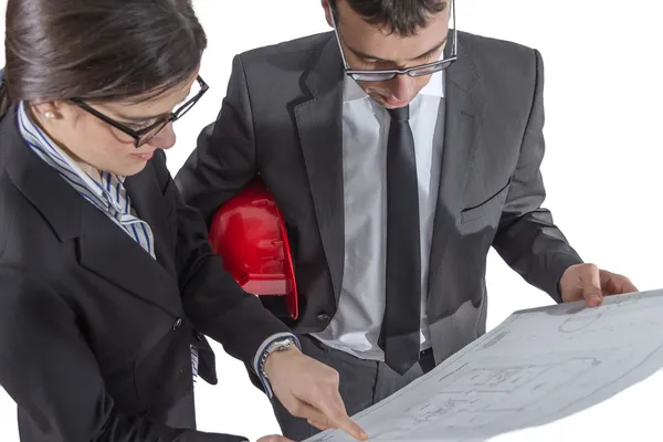 Casal de arquitetos revisando um projeto de casa em backgroun branco — Fotografia de Stock