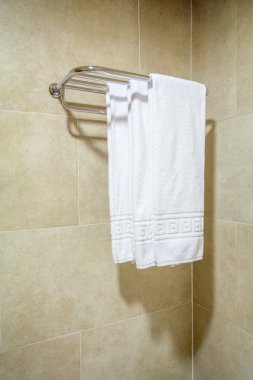 bir raf üzerinde asılı beyaz banyo havlusu