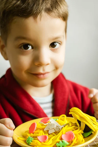 Retrato de niño con plato de espagueti de plastilina — Foto de Stock