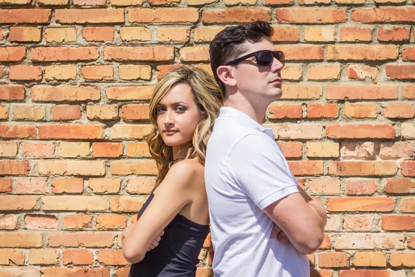 Retrato de pareja delante de la pared de ladrillo — Foto de Stock