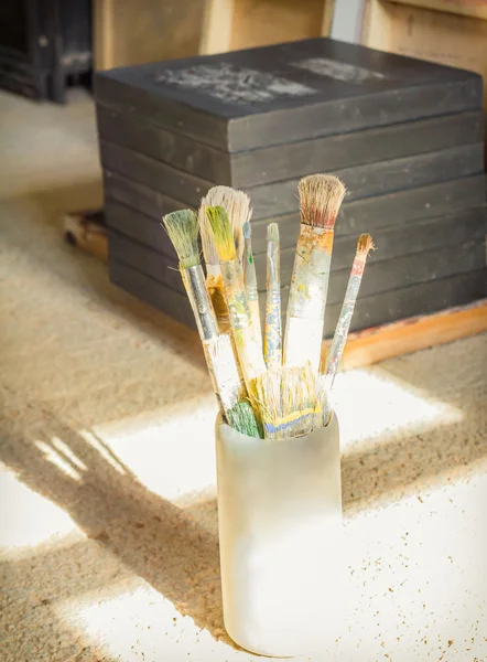 Paint brushes set in front of canvas — Stock Photo, Image