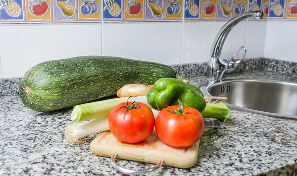 Verduras frescas en la tabla de cortar en la cocina — Foto de Stock