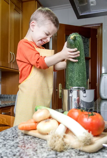 Cute chef criança cozinhar abobrinha grande em uma panela — Fotografia de Stock