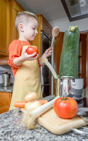 Cute chef criança cozinhar abobrinha grande em uma panela — Fotografia de Stock